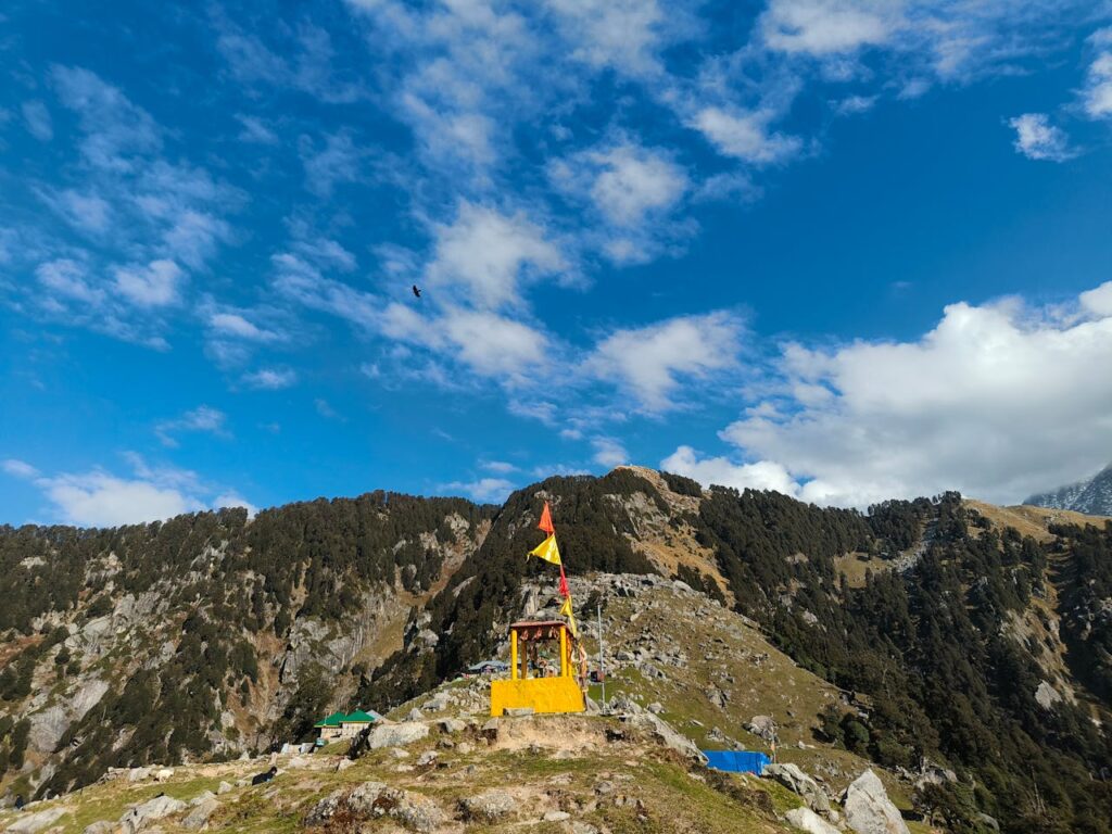 The Art of Drawing Readers In: Your attractive post title goes here Serene Himalayan landscape in Himachal Pradesh with a hilltop shrine under a clear blue sky.